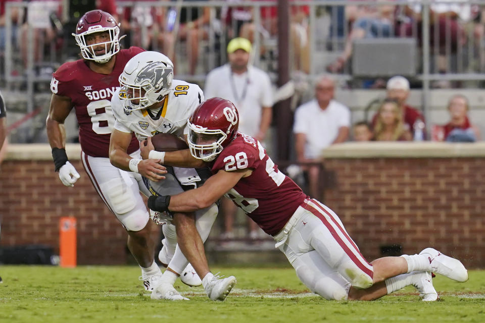 Oklahoma linebacker Danny Stutsman (28) brings down Kent State quarterback Collin Schlee (19) during the first half of an NCAA college football game Saturday, Sept. 10, 2022, in Norman, Okla. (AP Photo/Sue Ogrocki)