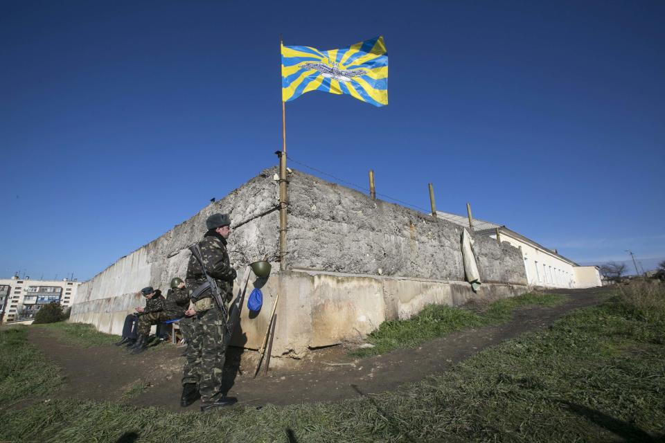 A Ukrainian serviceman stands guard on the territory of a military unit located in the village of Lyubimovka near a local airfield