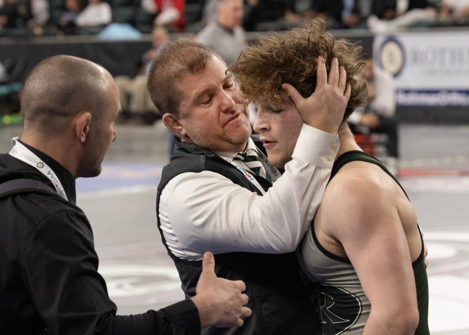 Raritan head coach Rob Nucci (left) hugs Zach Reilley after Reilley took seventh place at 144 pounds in the state tournament Saturday. Nucci is resigning as Raritan's head coach and will coach the Hazlet Middle School team next season.