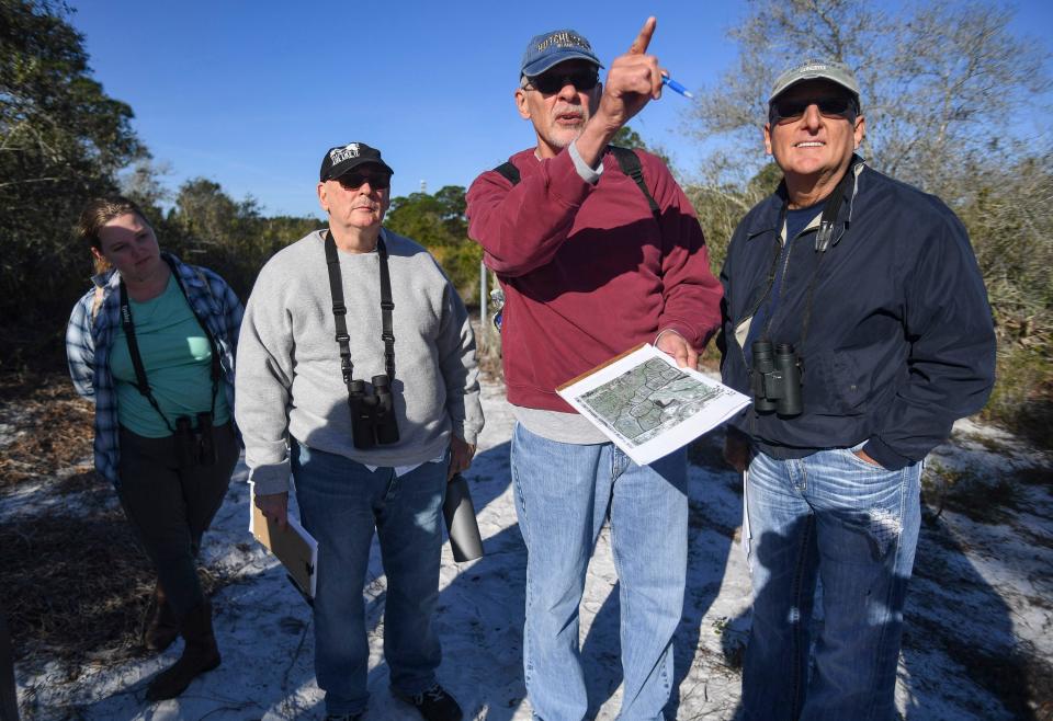 Volunteers from left, Julia Wiggins, Ira Alderman, Dave Miller and Jim Miller, point toward a scrub jay territory on their map, Feb. 1, 2024, at Wabasso Scrub Conservation Area. The volunteers, under a federal recovery permit, collect scientific information regarding observations they make of the eight families of jays that live on the property.