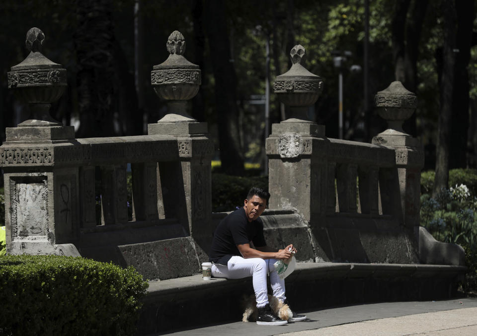 A man takes a coffee break on an empty park bench along Paseo de la Reforma street in Mexico City, Tuesday, June 2, 2020, amid the new coronavirus pandemic. While the federal government’s nationwide social distancing rule formally ended Monday, it is urging people in so-called “red” zones to maintain most of those measures — and so many people are falling ill and dying each day that those zones cover nearly the whole country. (AP Photo/Fernando Llano)