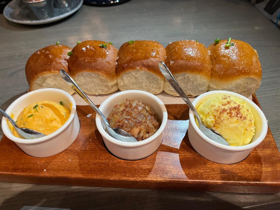 parker house rolls and three spreads on a platter at ale and compass in disney world