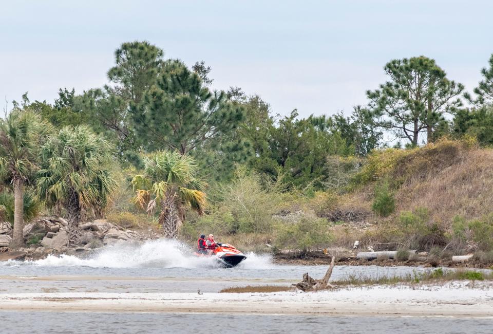 A personal watercraft rides past White Island in Bayou Davenport off Navy Point in Pensacola. A new $10.93 million grant award from the National Fish and Wildlife Foundation’s National Coast Resiliency Fund has given Escambia County approximately $29 million to fund living shoreline projects in the area around Naval Air Station Pensacola.