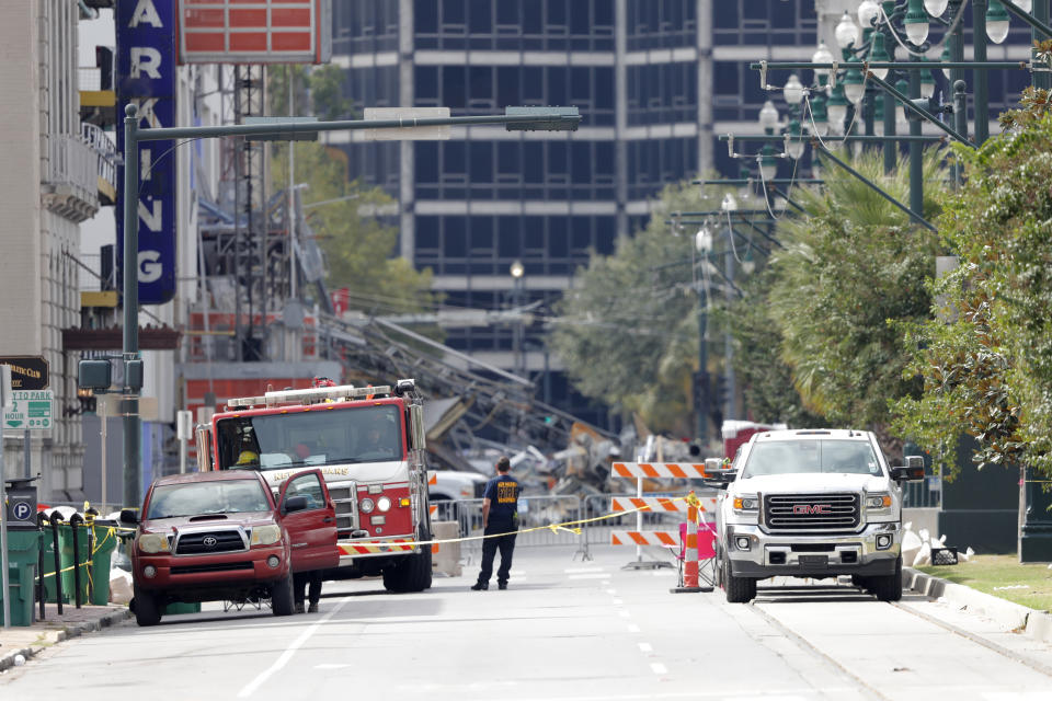 Fire department pesonnel stand by as workers prepare two unstable cranes for implosion at the collapse site of the Hard Rock Hotel, which underwent a partial, major collapse while under construction last Sat., Oct., 12, in New Orleans, Saturday, Oct. 19, 2019. Authorities plan to blow up the two towering construction cranes that have become unstable at the site of the collapsed hotel. They hope to bring down the cranes with series of small controlled blasts just ahead of approaching tropical weather. The mayor has imposed a state of emergency to seize property and force people out if necessary. They hope to avoid more damage to gas and power lines and historic buildings. (AP Photo/Gerald Herbert)