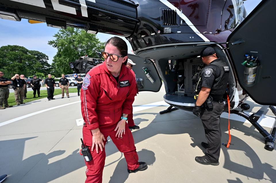 UMass flight nurse Stacy Cicio of Charlton ducks low after helping load a cage containing a police dog as part of a helicopter landing and K-9 air medical transport training exercise at Massachusetts State Police headquarters.