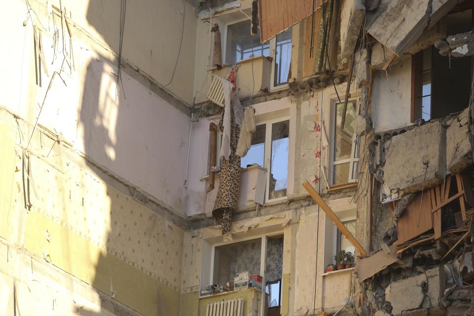 The scene of a park of a collapsed apartment building in Magnitogorsk, a city of 400,000 people, about 1,400 kilometers (870 miles) southeast of Moscow, Russia, Monday, Dec. 31, 2018. Russian emergency officials say that at least four people have died after sections of the apartment building collapsed after an apparent gas explosion in the Ural Mountains region. (AP Photo/Maxim Shmakov)