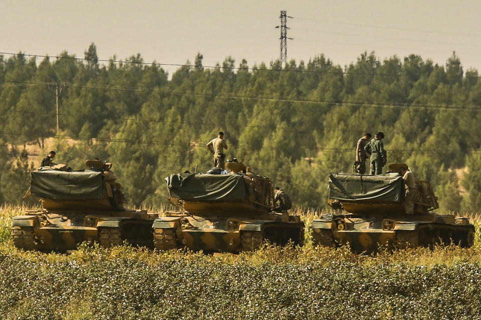 Turkish soldiers stand atop of their tanks at a staging area close to the border with Syria in Sanliurfa province, southeastern Turkey, Thursday, Oct. 17, 2019. U.S. Vice President Mike Pence and State Secretary Mike Pompeo were scheduled to arrive in Ankara and press Turkey's President Recep Tayyip Erdogan to accept a ceasefire in northeast Syria. (AP Photo/Emrah Gurel)