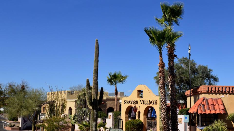 Entrance to the Spanish Village, a period looking shopping area in Carefree, Arizona, with local cactus and other vegetation.