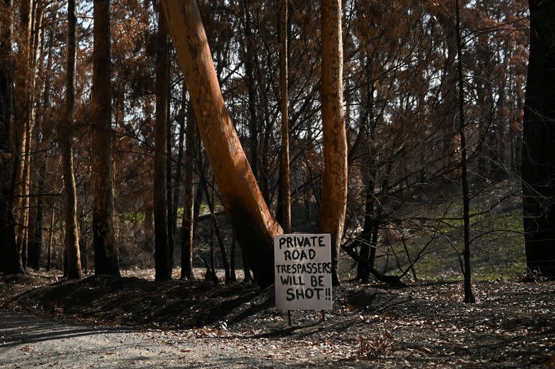 A sign warning potential trespassers to turn around is pictured at the front of a property burnt during the recent bushfires near Batemans Bay