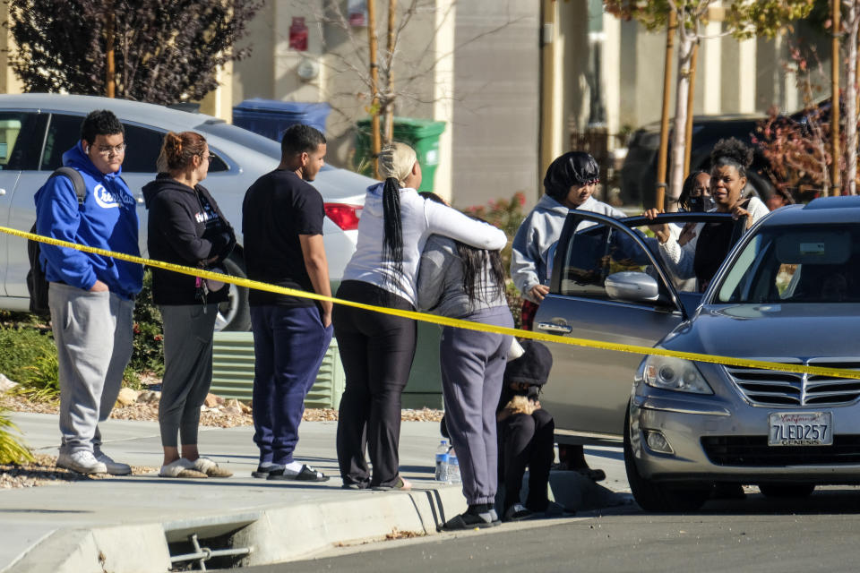 FILE - Neighbors react near a home where five bodies were found dead, in the city of Lancaster, Calif., on Nov. 29, 2021. A jury convicted a 32-year-old man Tuesday, March 12, 2024, in the 2021 slayings of his four children, including a boy not yet 2 years old and their grandmother, in Southern California. The slayings occurred in the family's home in Lancaster, a city in the Antelope Valley high desert community north of Los Angeles. (AP Photo/Ringo H.W. Chiu, File)