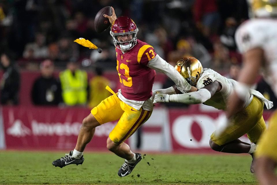 Southern California quarterback Caleb Williams, left, escapes a tackle by Notre Dame defensive lineman Justin Ademilola as a flag is thrown on the play during the second half of an NCAA college football game Saturday, Nov. 26, 2022, in Los Angeles
