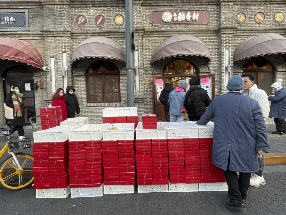 Stacks of pre-packed new year gift boxes are stacked near the entrance of the flagship store of Daoxiangcun, one of Beijing’s best-known Chinese bakeries, on Jan. 14, 2023. (AP Photo/Caroline Chen)