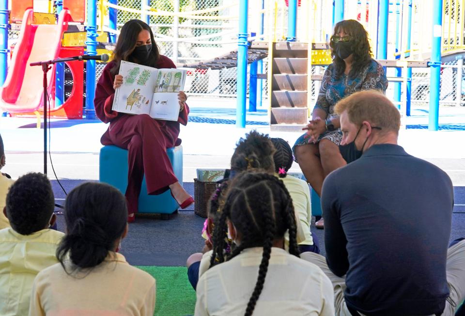 Duchess Meghan reads from her book "The Bench," as Prince Harry (bottom right) and second-grade students listen during their visit to P.S. 123, the Mahalia Jackson School, in New York's Harlem neighborhood on Sept. 24, 2021.