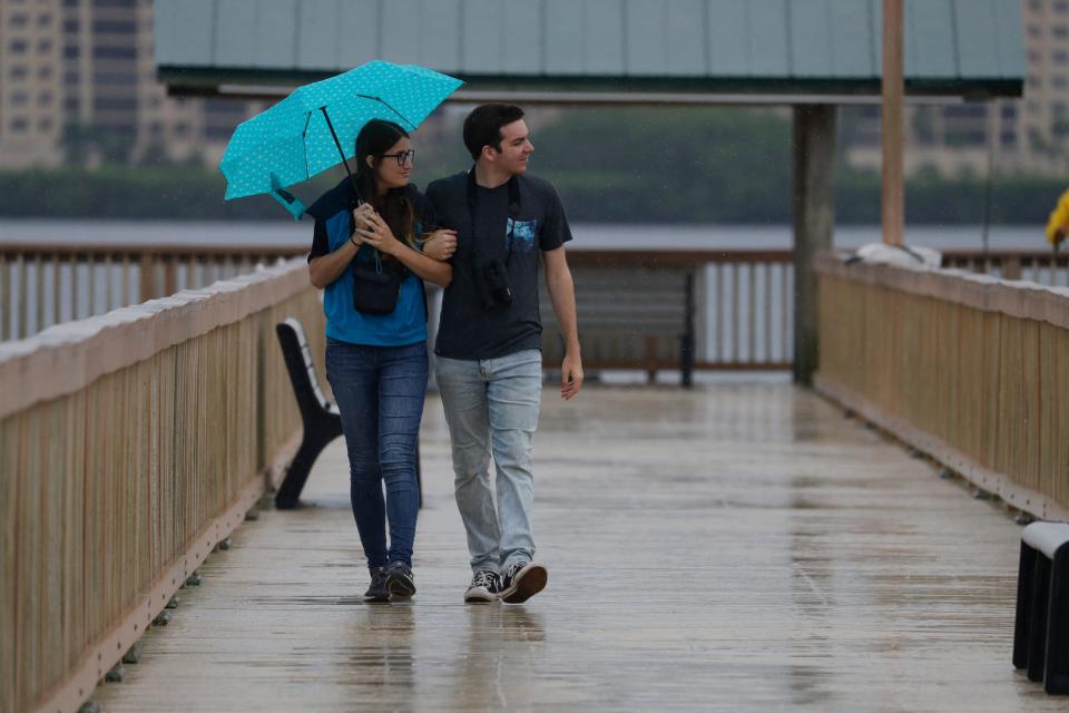 Ryan and Iulia (cq) Poe, visiting from Columbus, Ohio, check out an osprey as they take a stroll along a wet Cape Coral Yacht Club Pier Friday, June 3, 2022. The couple enjoys bird watching and was here on vacation. Rain and dark skies were prominent in the morning as a Tropical Storm watch was issued earlier for the west coast of Florida. 