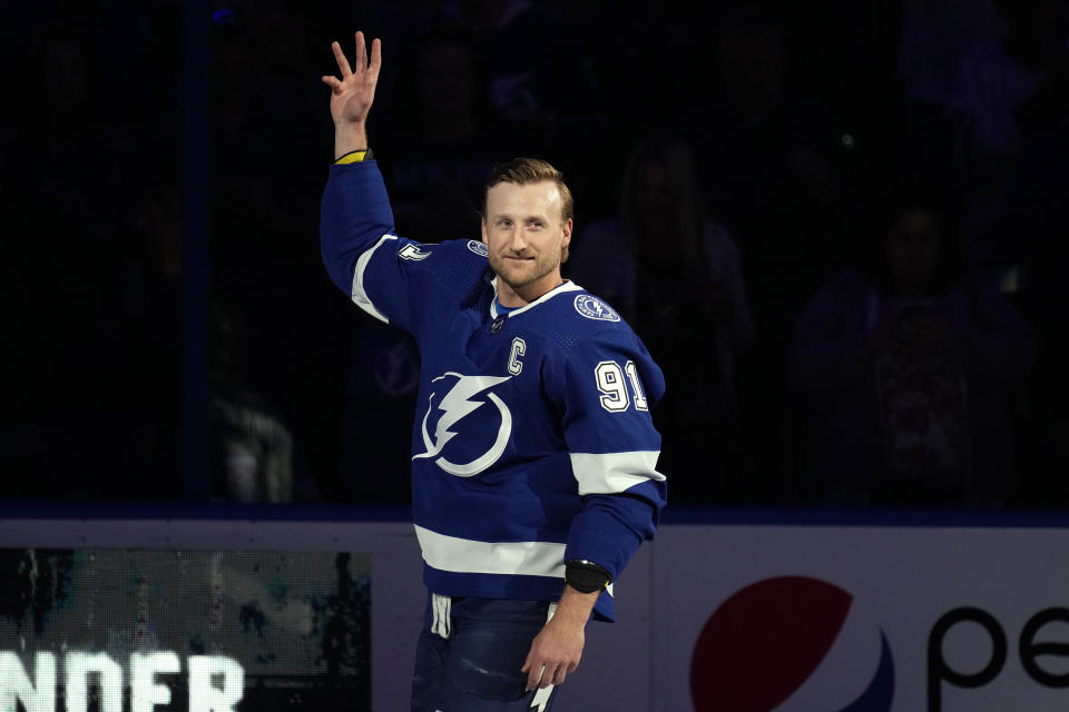 Tampa Bay Lightning center Steven Stamkos (91) waves to the fans after being honored for playing in his 1,000th career game before an NHL hockey game Tuesday, April 11, 2023, in Tampa, Fla. (AP Photo/Chris O'Meara)