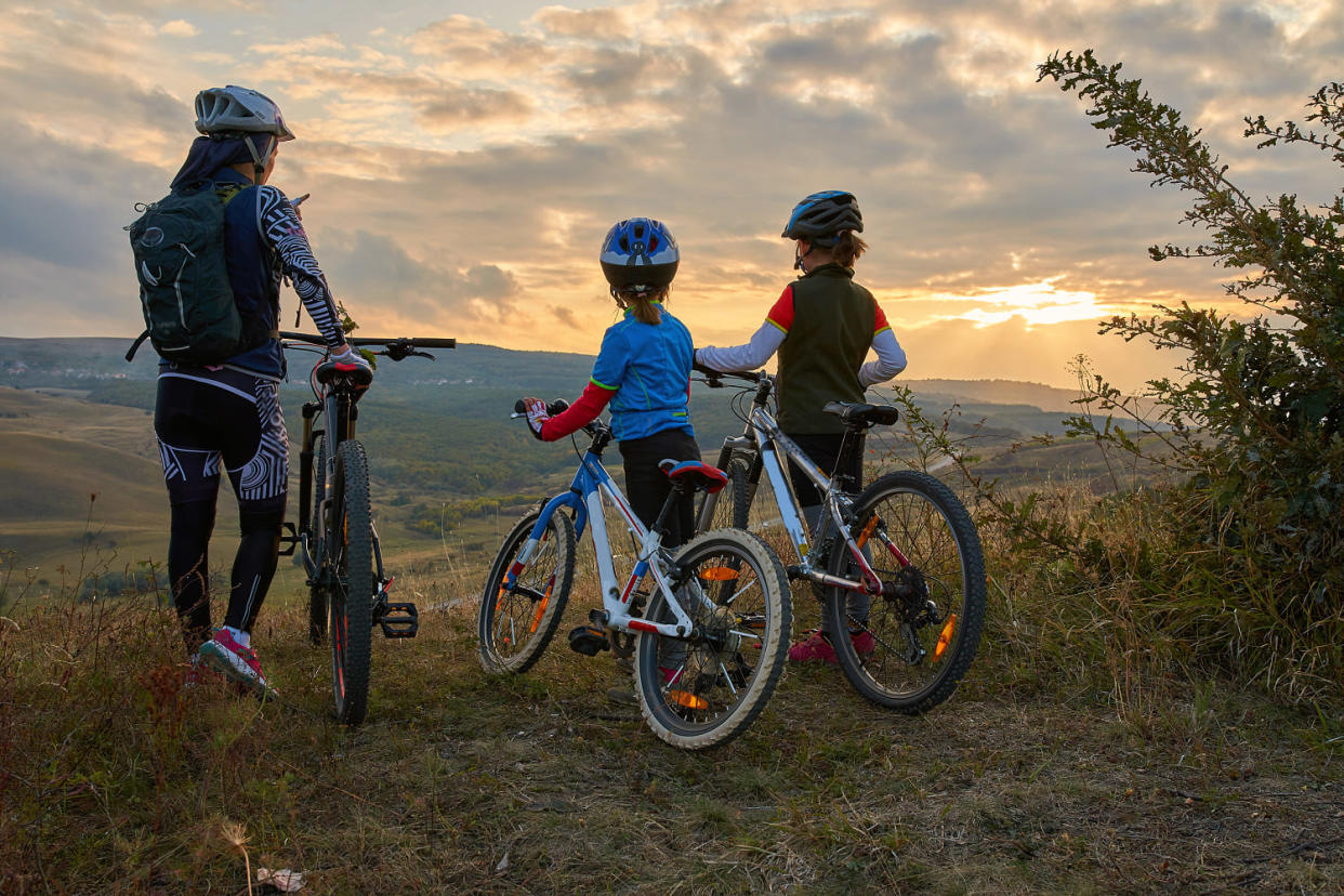 Happy mountain bike family,  outdoors have fun together on a summer afternoon sunset, cycling girls activity (Sebastian Condrea / Getty Images)