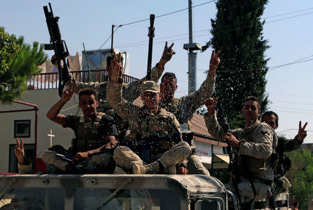 Lebanese army soldiers are seen flashing victory signs in Qaa, Lebanon August 21, 2017. REUTERS/ Ali Hashisho