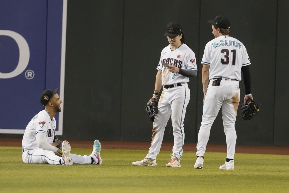 From left to right, Arizona Diamondbacks outfielders Lourdes Gurriel Jr., Corbin Carroll, and Jake McCarthy laugh during a pitching change against the Colorado Rockies during the ninth inning of a baseball game, Monday, May 29, 2023, in Phoenix. (AP Photo/Darryl Webb)