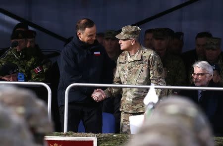 Polish President Andrzej Duda (L) shakes hands with Commander of U.S. Forces in Europe, General Curtis Scaparrotti during U.S.-led NATO troops welcoming ceremony at polygon near Orzysz, Poland, April 13, 2017. REUTERS/Kacper Pempel