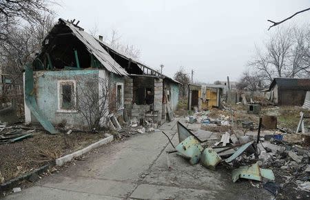 A man enters a destroyed house in the Spartak area near Sergey Prokofiev International Airport in Donetsk November 18, 2014. REUTERS/Antonio Bronic