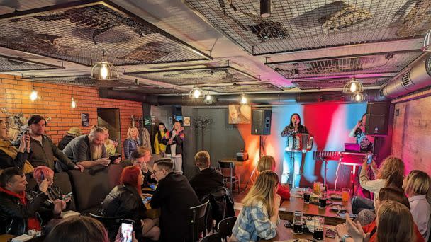 PHOTO: Patrons attend a fundraising concert at Offensive, a new cafe in Kyiv, Ukraine, decorated with items representing the country's fight against the Russian invasion. (Yulia Drozd/ABC News)