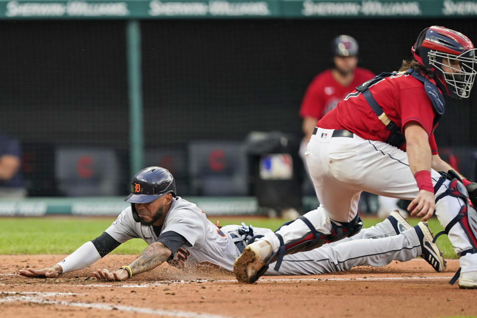 Detroit Tigers' Harold Castro slides safely into home plate as Cleveland Indians catcher Austin Hedges waits for the ball in the fourth inning in the first baseball game of a doubleheader, Wednesday, June 30, 2021, in Cleveland. (AP Photo/Tony Dejak)