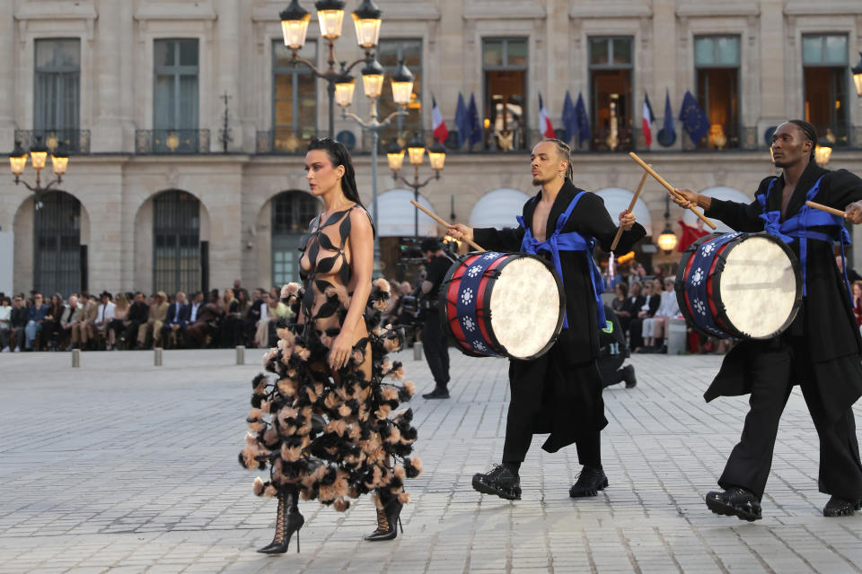 Perry walks the runway during Vogue World: Paris at Place Vendome 4 in Paris, France wearing black strappy boots and archival Noir Kei Ninomiya gown.