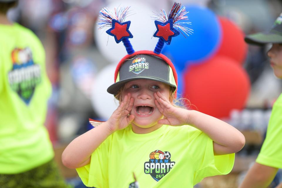 A child shouts from the Sports 24/7 float in the Farragut Independence Day Parade along Kingston Pike in Farragut, Tenn. on Monday, July 4, 2022.