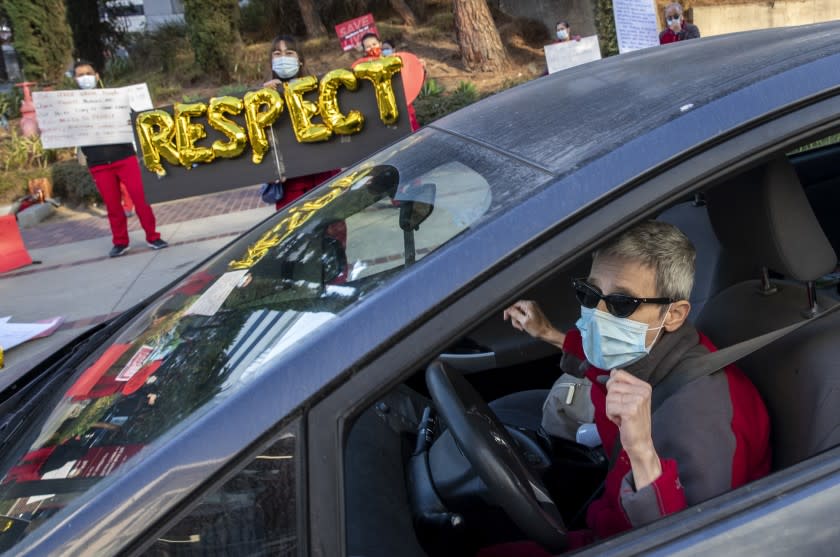 LINCOLN HEIGHTS, CA - DECEMBER 02: Nurse Helena Harvilicz, right, dances in her car to Aretha Franklin's "Respect" at Keck Hospital of USC where nurses are protesting unsafe working conditions at the hospital Wednesday, Dec. 2, 2020 in Lincoln Heights, CA. (Brian van der Brug / Los Angeles Times)