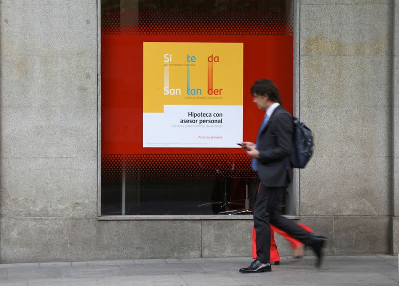 Man walks past a mortgage advertisement at a Santander bank branch in Madrid