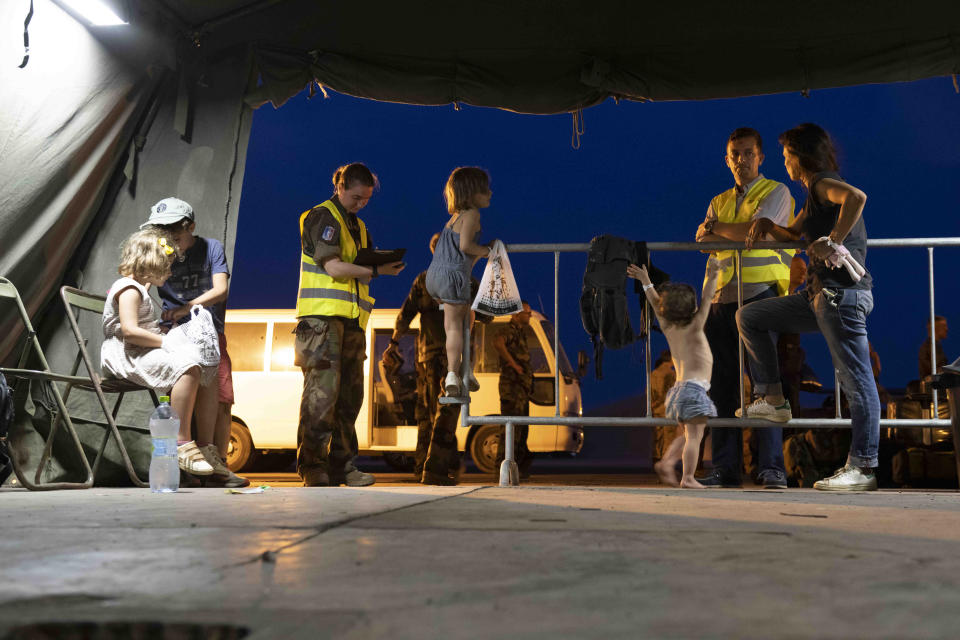 This photo provided by the French Army shows French citizens after arriving in Djibouti, Sunday, April 23, 2023. Two French military planes evacuating about 200 people from multiple countries left Khartoum on Sunday for Djibouti as France urged all parties to stop fighting and return to political dialogue, in a statement by the Foreign Ministry and Defense Ministry. (Etat Major des Armies via AP)