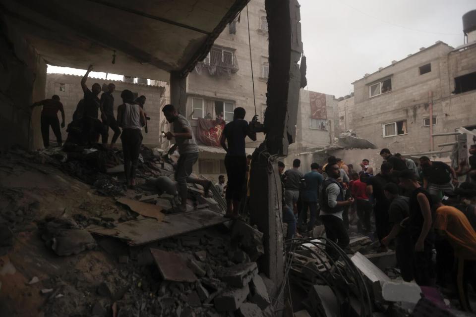 Palestinians look for survivors under the rubble of a house after an airstrike