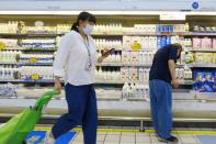 Customer picks milk from refrigerator shelves at a supermarket in Beijing