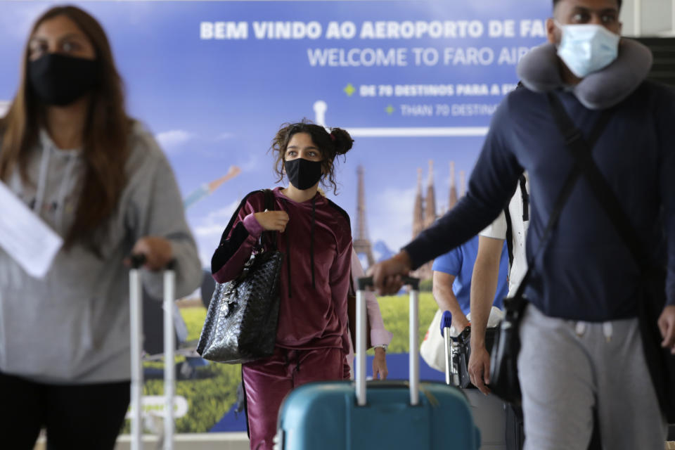 Passengers of a flight from the United Kingdom arrive at Faro airport, outside Faro, in Portugal's southern Algarve region, Monday, May 17, 2021. British vacationers began arriving in large numbers in southern Portugal on Monday for the first time in more than a year, after governments in the two countries eased their COVID-19 pandemic travel restrictions. (AP Photo/Ana Brigida)