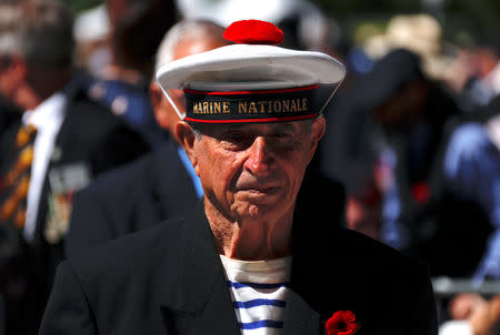 A former French Navy sailor wearing his old uniform listens during a memorial service at the ANZAC Memorial to mark the centenary of the Armistice ending World War One, in Sydney, Australia, November 11, 2018. REUTERS/David Gray