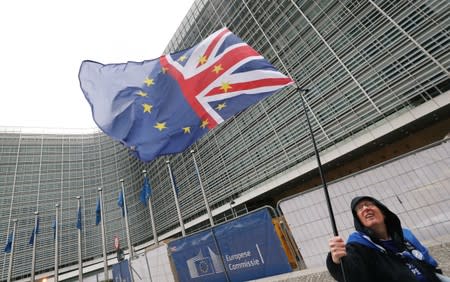 A woman holds a flag during a protest against Brexit outside the EU Commission headquarters in Brussels