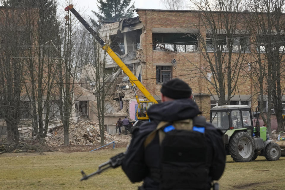 A police officer stands guard at the scene of a drone attack in the town of Rzhyshchiv, Kyiv region, Ukraine, Wednesday, March 22, 2023. (AP Photo/Efrem Lukatsky)