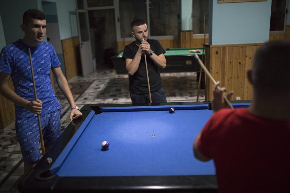 Mientras esperan a que se levanten las restricciones y puedan viajar a la UE en busca de trabajo, los jóvenes de Ballsh pasan los días en los bares y cafeterías de la ciudad. (Foto: Daniel Cole / AP).