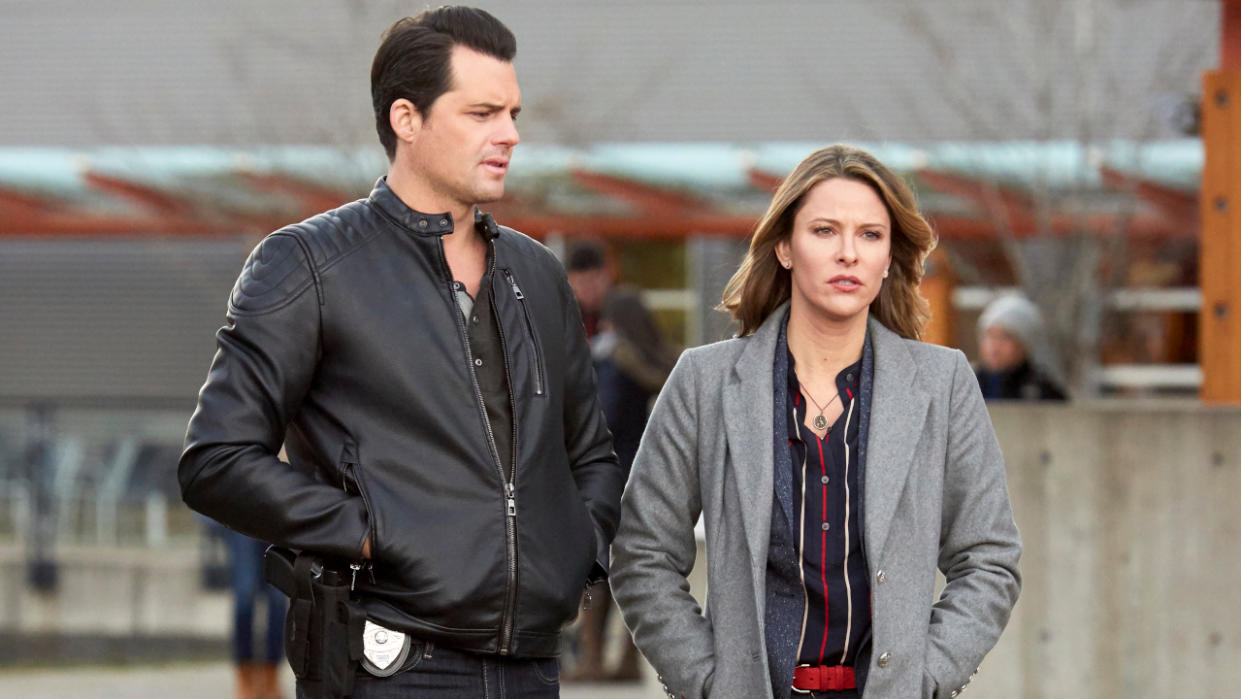  Kristoffer Polaha and Jill Wagner moodily walking in an outdoor scene in Mystery 101. 