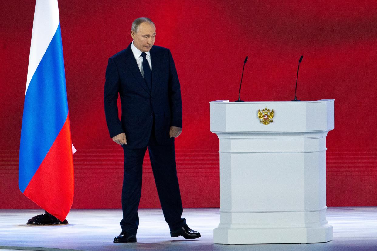 <p>Russian president Vladimir Putin leaves the hall after his annual state of the nation address today (21 April)</p> (AP)