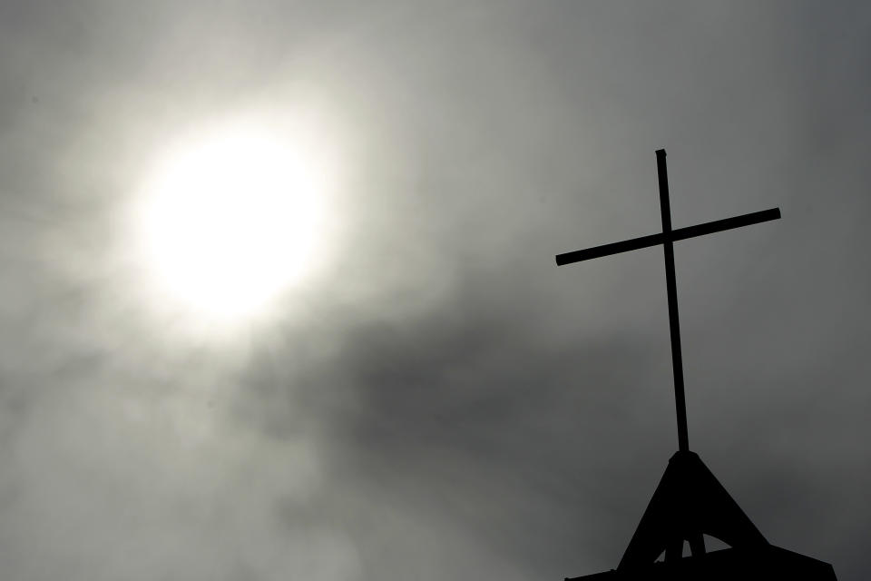 FILE - In this April 8, 2010 file photo a cross sits on top of a church in Berlin, Germany. In September 2018, the German Catholic Church released a devastating report that concluded at least 3,677 people were abused by clergy between 1946 and 2014. Pope Francis' high-stakes sex abuse prevention summit is meant to call attention to the crisis as a global problem that requires a global response. (AP Photo/Markus Schreiber, File)