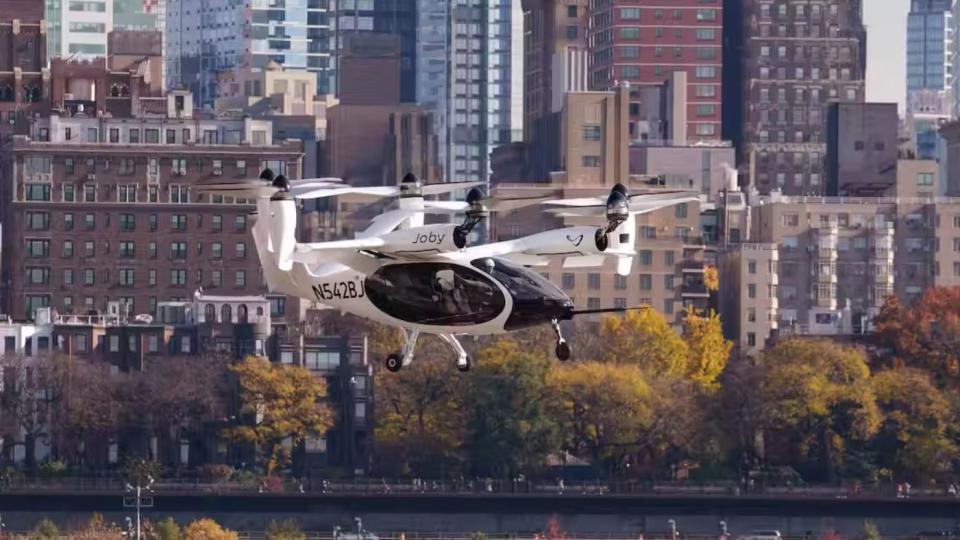an evtol plane flying and hovering over a city