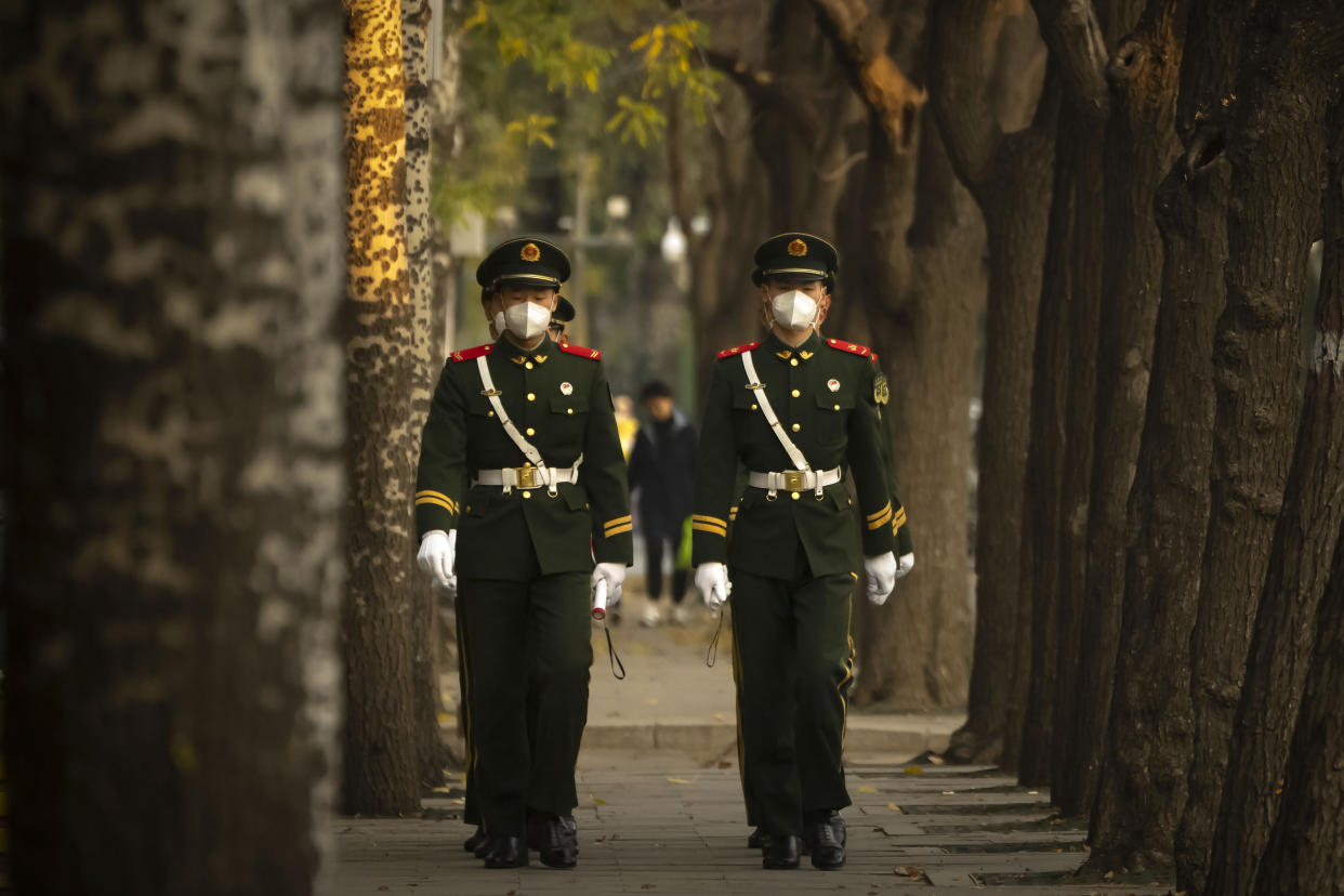 Chinese paramilitary police wearing face masks walk in formation along a street in Beijing, Thursday, Nov. 17, 2022. Chinese authorities faced more public anger Thursday after a second child's death was blamed on overzealous anti-virus enforcement, adding to frustration at controls that are confining millions of people to their homes and sparked fights with health workers. (AP Photo/Mark Schiefelbein)