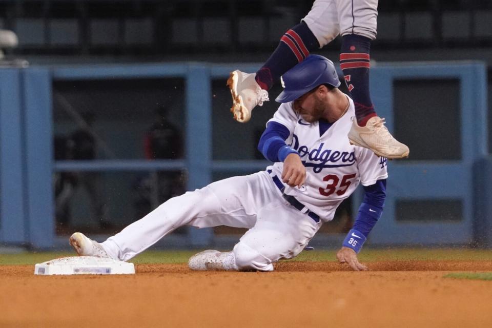 Cody Bellinger steals second as Cleveland Guardians second baseman Andres Gimenez leaps to catch a high throw.