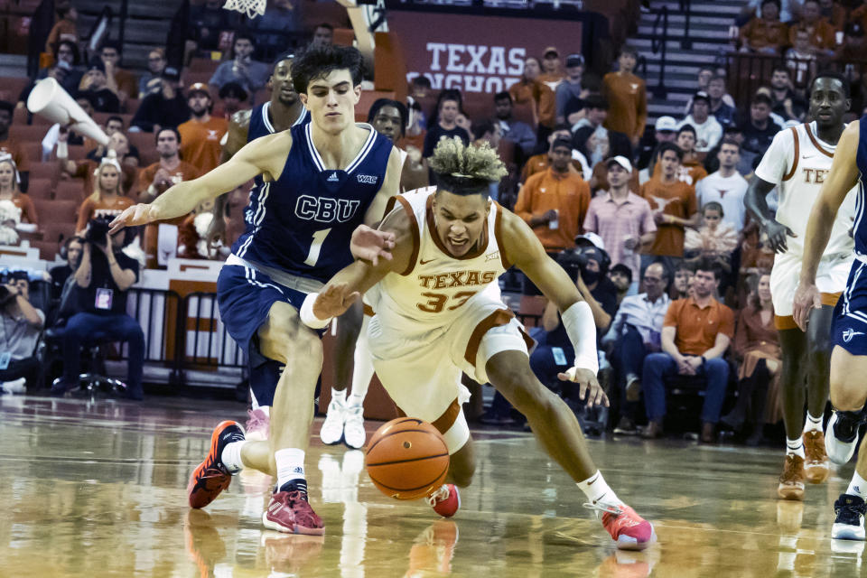 Texas forward Tre Mitchell, left, goes for a loose ball against California Baptist guard Taran Armstrong, left, during the first half of an NCAA college basketball game, Wednesday, Nov. 24, 2021, in Austin, Texas. (AP Photo/Michael Thomas)