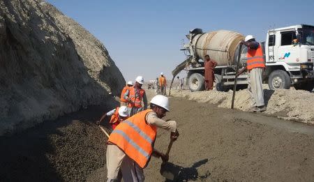 Labourers work on the development site of a storm water drain along a newly constructed road on the outskirts of Gwadar, Pakistan January 26, 2016. REUTERS/Syed Raza Hassan