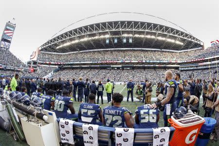 Oct 1, 2017; Seattle, WA, USA; Seattle Seahawks defensive tackle Jarran Reed (90), defensive end Frank Clark (55), defensive end Michael Bennett (72) and defensive end Cliff Avril (56) sit on the bench during the national anthem before a game against the Indianapolis Colts at CenturyLink Field. Seattle Seahawks center Justin Britt (68) stands next to Avril. Mandatory Credit: Joe Nicholson-USA TODAY Sports