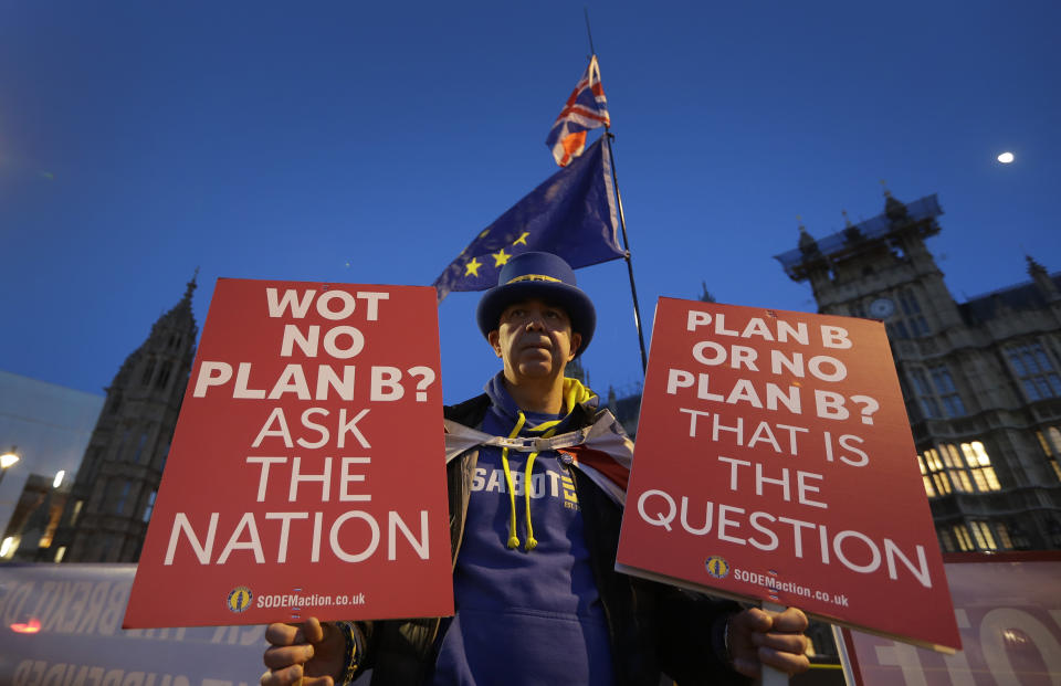A pro European demonstrator holds banners near parliament in London, Thursday, Jan. 17, 2019. British Prime Minister Theresa May is reaching out to opposition parties and other lawmakers Thursday in a battle to put Brexit back on track after surviving a no-confidence vote. (AP Photo/Kirsty Wigglesworth)