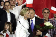 Incumbent President Andrzej Duda is hugged by his wife Agata Kornhauser-Duda in Pultusk, Poland, Sunday, July 12, 2020. An exit poll in Poland's presidential runoff election shows a tight race that is too close to call between the conservative incumbent, Andrzej Duda, and the liberal Warsaw mayor, Rafal Trzaskowski.(AP Photo/Czarek Sokolowski)