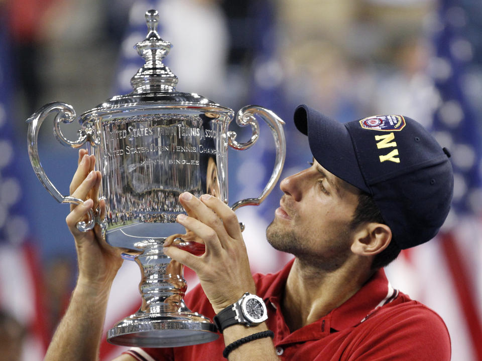 FILE - Novak Djokovic of Serbia poses with the trophy after winning the men's championship match against Rafael Nadal of Spain at the U.S. Open tennis tournament in New York, Monday, Sept. 12, 2011. Djokovic will be trying to set the record for the most Grand Slam singles trophies won by a man when he goes for what would be No. 23 against Casper Ruud in the French Open final on Sunday, June 11, 2023. Djokovic enters that match with 22, tied with his rival Rafael Nadal. Roger Federer, who announced his retirement last year, is next with 20. (AP Photo/Charles Krupa, File)
